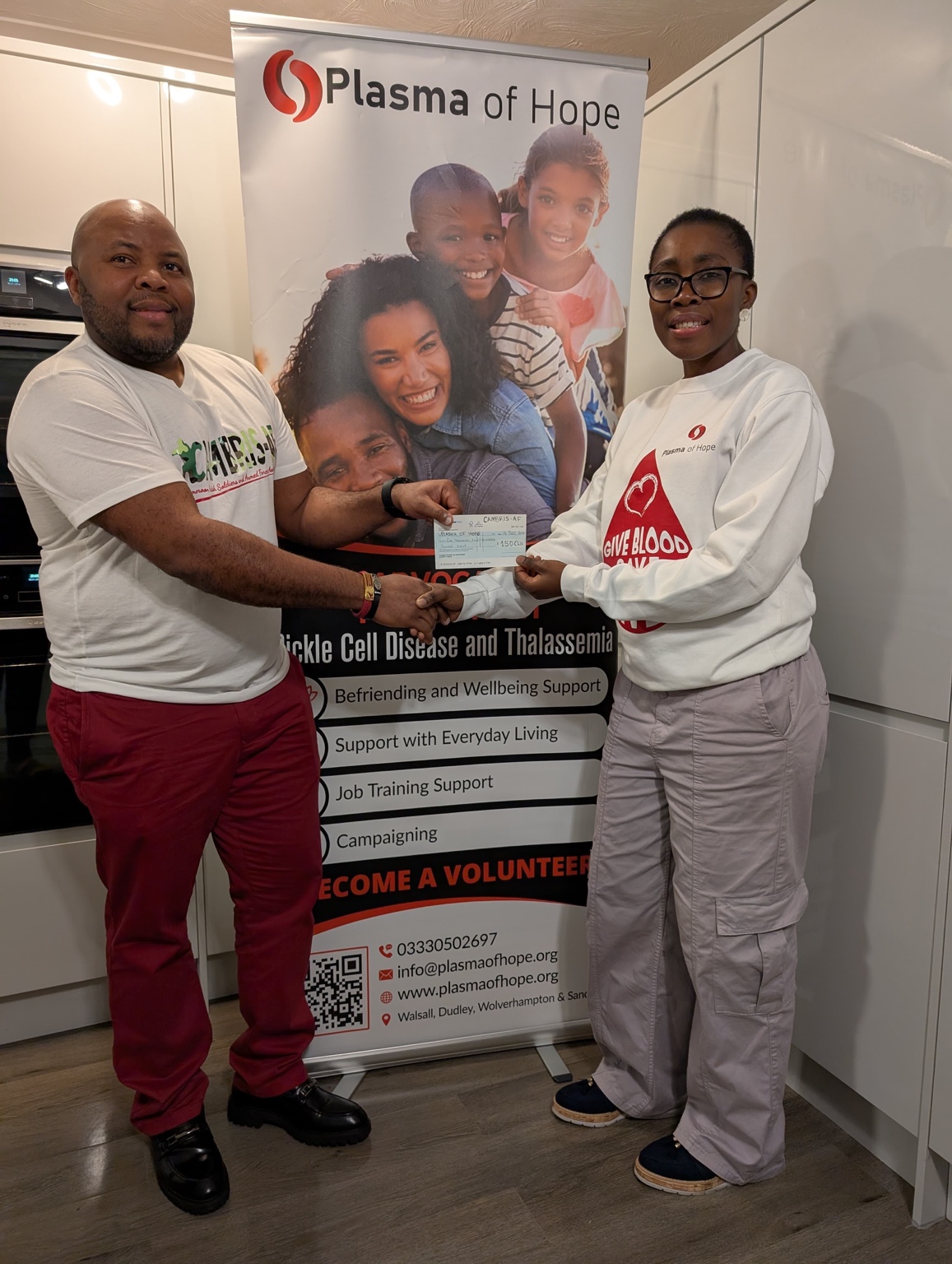 CAMBRIS-AF representative presenting support to a Plasma of Hope representative during a community engagement visit.