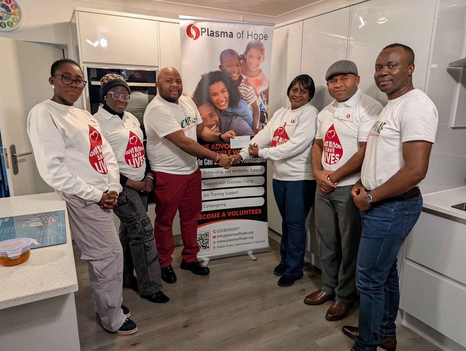 CAMBRIS-AF and Plasma of Hope representatives standing together in partnership for community support and inclusion.